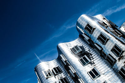 Low angle view of buildings against blue sky