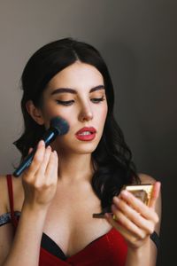 Close-up of young woman makeup artist red lips