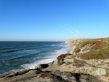 Scenic view of sea against clear blue sky