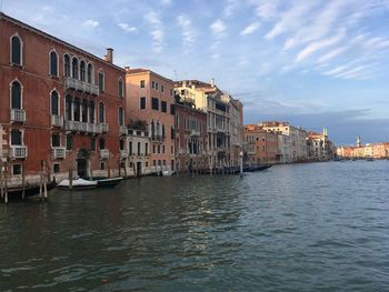 Buildings in city against cloudy sky