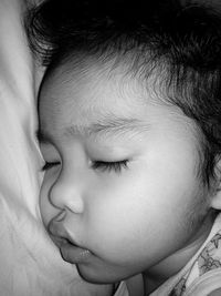 Close-up of cute baby sleeping on bed