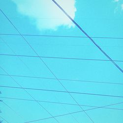 Low angle view of power lines against blue sky