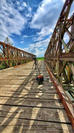 Footbridge on footpath against sky