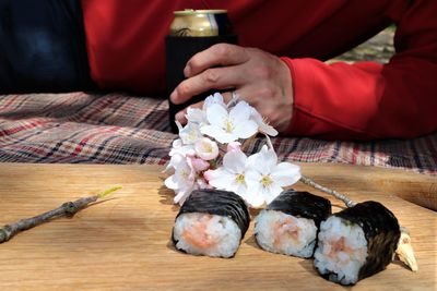 Close-up of man holding flowers on table