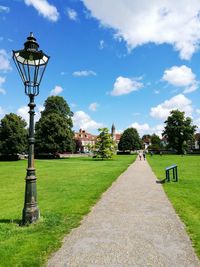 Walkway in park against sky