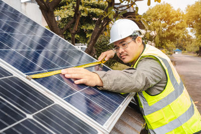 Rear view of man standing on solar panel