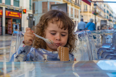 Cute girl eating ice cream outdoors