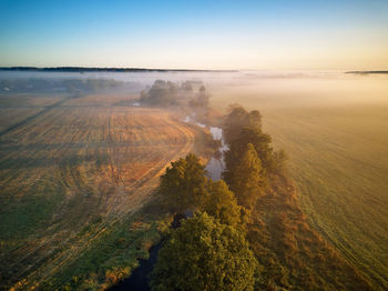 Autumn foggy sunrise. colorful misty morning dawn. fall rural scene. small river with trees