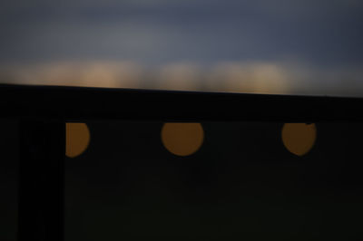 Close-up of railing against sky during sunset