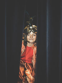 Portrait of girl standing behind curtain