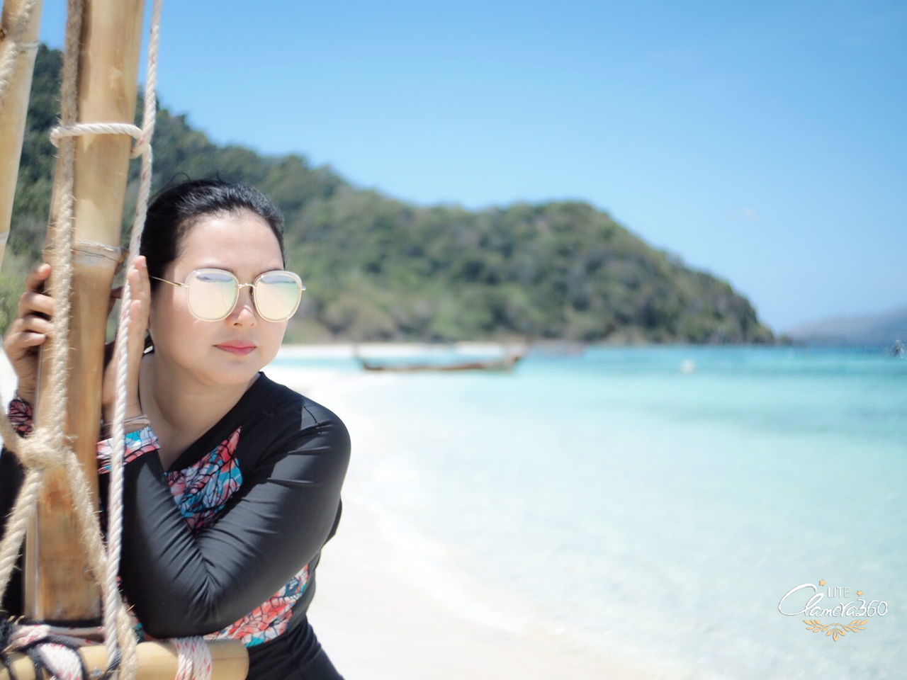 water, one person, land, sea, nature, beach, adult, young adult, glasses, portrait, blue, vacation, holiday, sky, day, trip, women, leisure activity, fashion, travel, relaxation, outdoors, tranquility, copy space, hairstyle, black hair, clothing, beauty in nature, standing, sunlight, lifestyles, looking at camera, scenics - nature, focus on foreground, waist up, eyeglasses, casual clothing, looking, travel destinations, emotion, smiling, front view, sunglasses, tranquil scene, clear sky, photo shoot, sunny