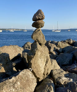 Scenic view of rocks on sea shore against clear sky