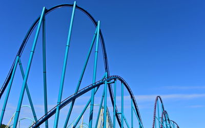 Low angle view of ferris wheel against blue sky