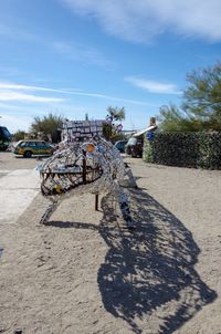 Shadow of tree on sand at beach against sky