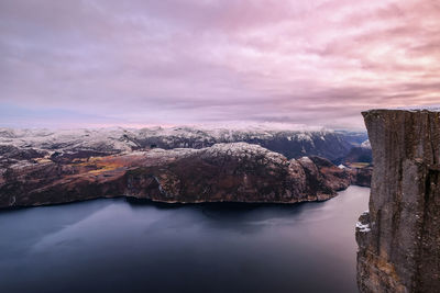 Scenic view of lake by rock formation against sky