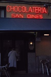 Man standing at illuminated store