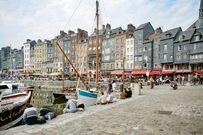 Boats in canal by buildings in city