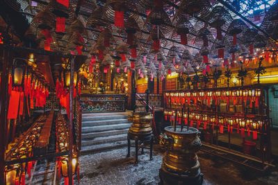 Illuminated lanterns hanging by building in temple at night
