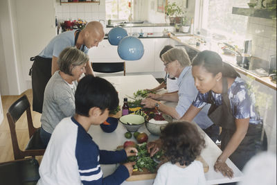 High angle view of family preparing asian food at table