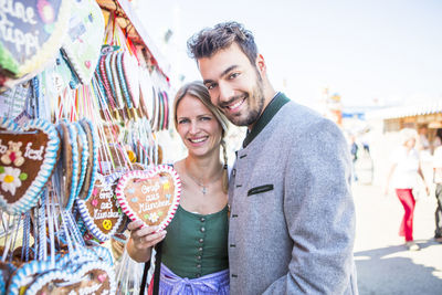Portrait of smiling couple standing by store