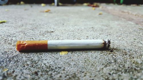 Close-up of cigarette on footpath