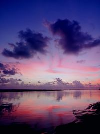 Scenic view of lake against dramatic sky during sunset