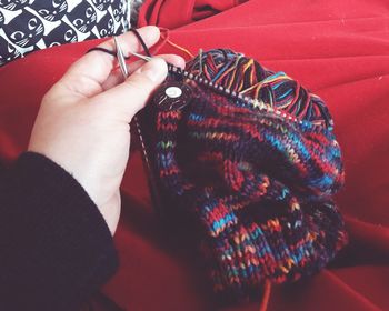 Cropped hand of woman knitting hat