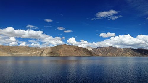 Scenic view of lake and mountains against blue sky