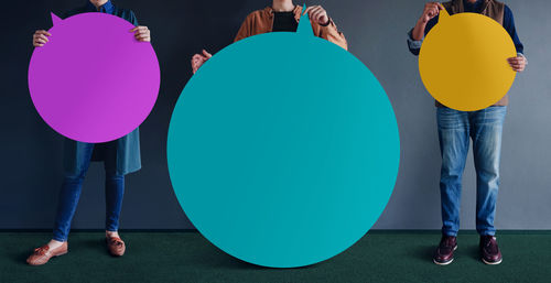 Low section of people standing on balloons