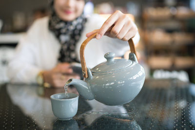 Hand holding ice cream cone on table