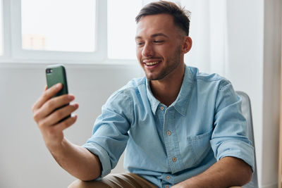 Young man using mobile phone at home