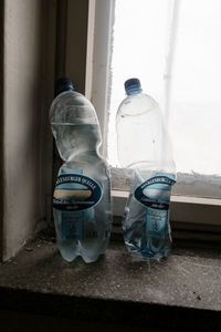 Close-up of abandoned bottle on window sill