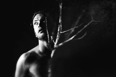 Composite black and white image of a middle-aged male with a tree branch coming out of his chest