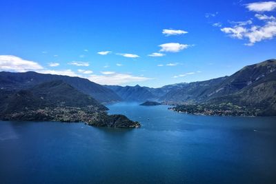 Scenic view of lake and mountains against blue sky