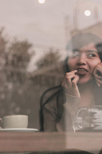 Portrait of smiling woman holding drink at restaurant