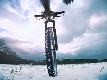 Bicycle wheel in the snow. detailed extreme close up low angle view. snowy filed in open landscape.