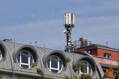 Mobile antenna in the roof of a building, against blue sky