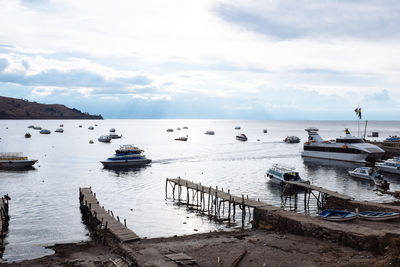 Boats moored on sea against sky