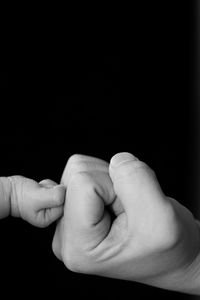 Close-up of hands against black background