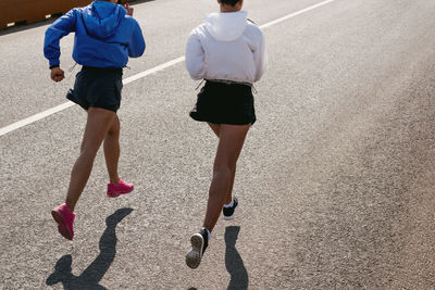 High angle view of female friends jogging on road