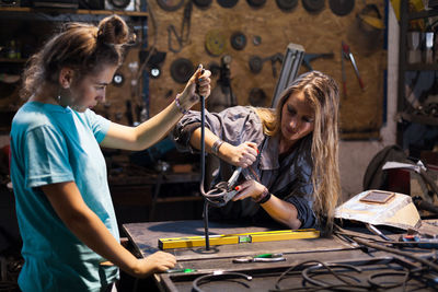 Female coworkers working at table in workshop