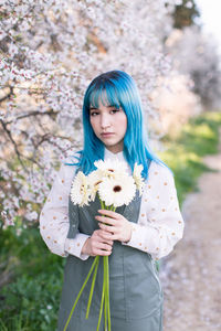 Portrait of a beautiful young woman holding flower