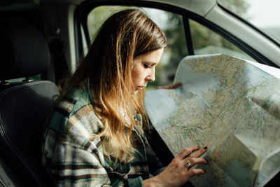 Woman looking through car window