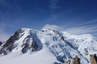 Scenic view of snowcapped mountains against blue sky