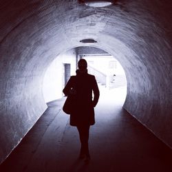 Full length of woman walking in tunnel