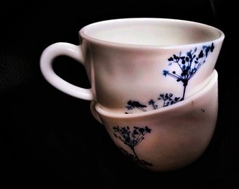 Close-up of coffee cup on table against black background