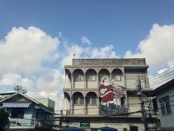 Low angle view of santa claus billboard on building against sky