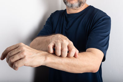Midsection of man gesturing against white background