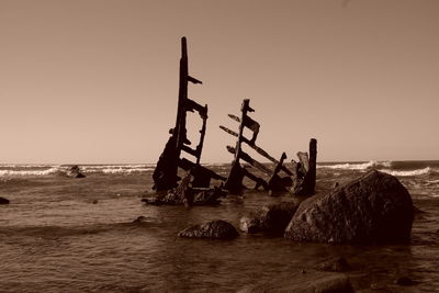 Statue on beach against clear sky