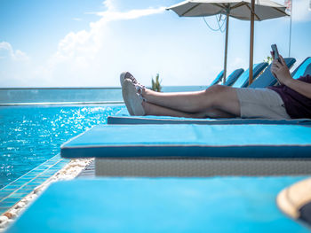 Low section of man relaxing in swimming pool